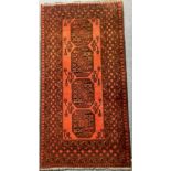 Red ground fringed woollen rug with four decorative panels, 100 x 200 cm. Not available for in-house