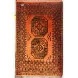Red ground woollen fringed rug with two decorative panels, 140 x 85 cm. Not available for in-house