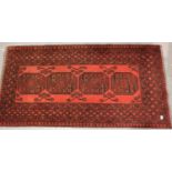 Red ground fringed woollen rug with four decorative panels, 100 x 200 cm. Not available for in-house