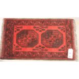 Red ground woollen fringed rug with two decorative panels, 60 x 90 cm. Not available for in-house