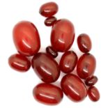 Collection of fourteen cherry amber beads, 49g. Largest bead L: 29 mm. P&P Group 1 (£14+VAT for
