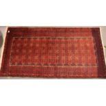 Red ground woollen fringed rug with 52 panels and geometric design border, 200 x 100 cm. Not