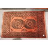 Red ground woollen fringed rug with two decorative panels, 140 x 85 cm. Not available for in-house