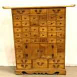 An oak forty four drawer spice cabinet with central cupboard, 95 x 24 x 95 cm H. Not available for