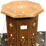 A Middle Eastern carved octagonal table, inlaid with mother of pearl with a later bevelled glass