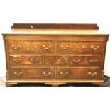 An early 20th century oak mule chest, cross banded with five drawers, two faux drawers with