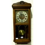 An early 20th century oak cased wall clock, the case with arched and bevelled glass and silvered