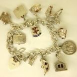 Silver charm bracelet with ten charms and padlock clasp, 47g. P&P Group 1 (£14+VAT for the first lot