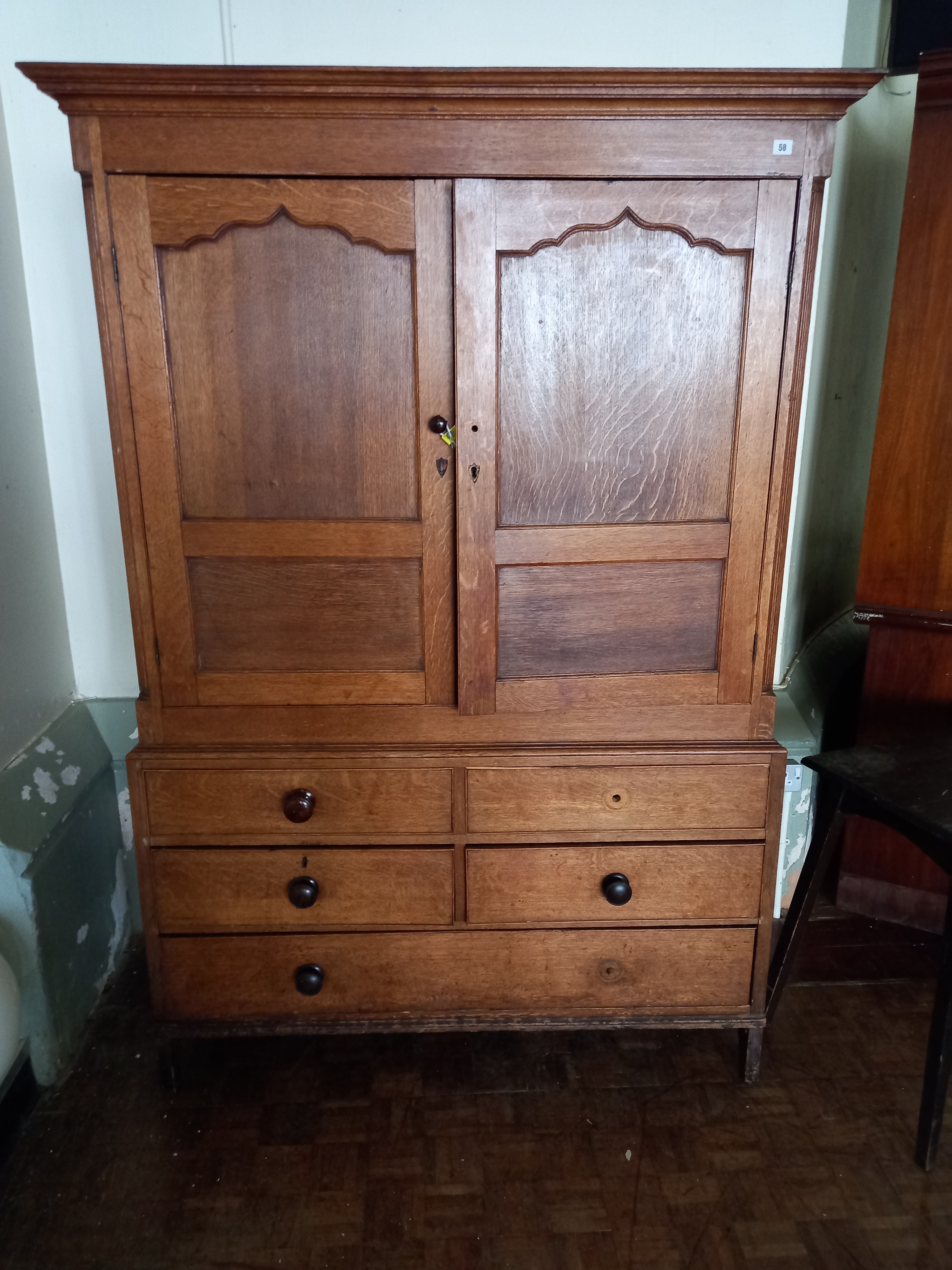 A late 18th/ early 19th century oak linen press with drawers beneath.