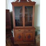 A Victorian pitch pine glazed bookcase with carved door panels