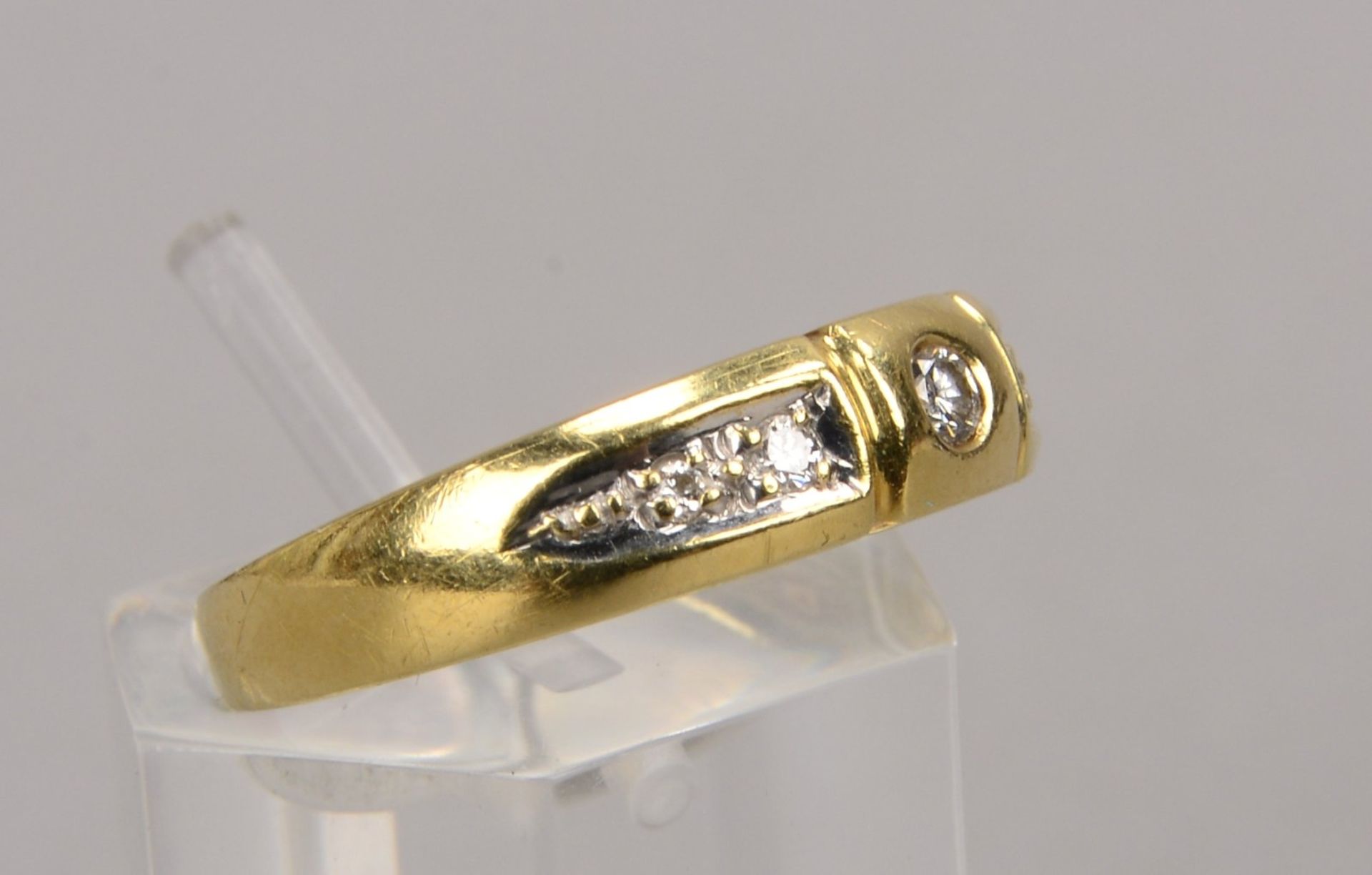 Ring, 585 GG, besetzt mit einzelnem kleinem Brillant von ca. 4 ct, sowie mit Begleitdiamanten/zusamm