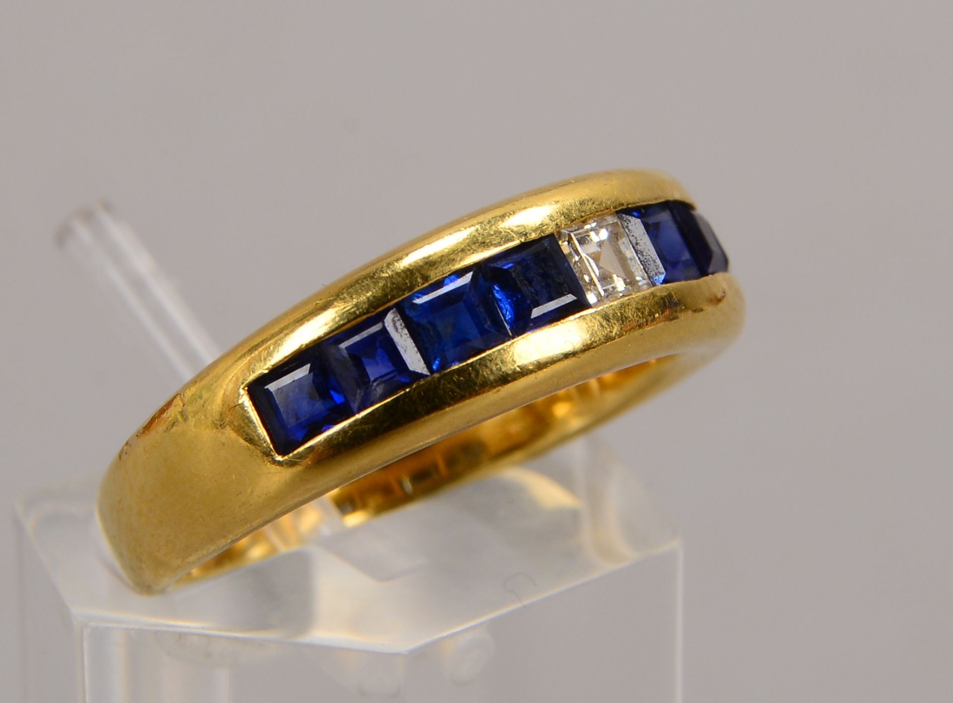 Ring, 750 GG (gez.), besetzt mit einzelnem Diamant, Stein im Carr&eacute;schliff, und 8x Saphiren, S