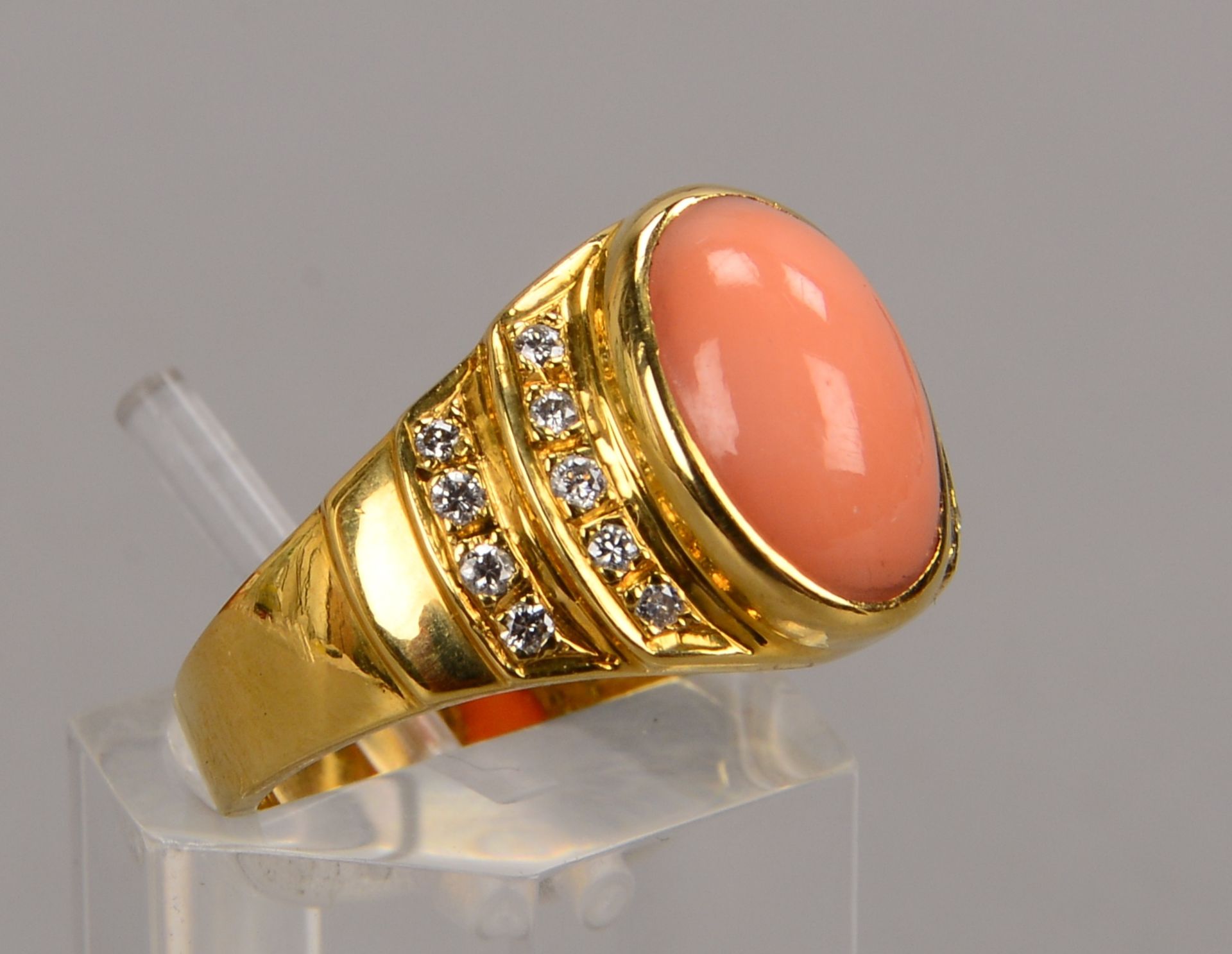 Ring, 750 GG (gez.), besetzt mit einem Korallencabochon und 18x kleinen Brillanten/zusammen ca. 0,18