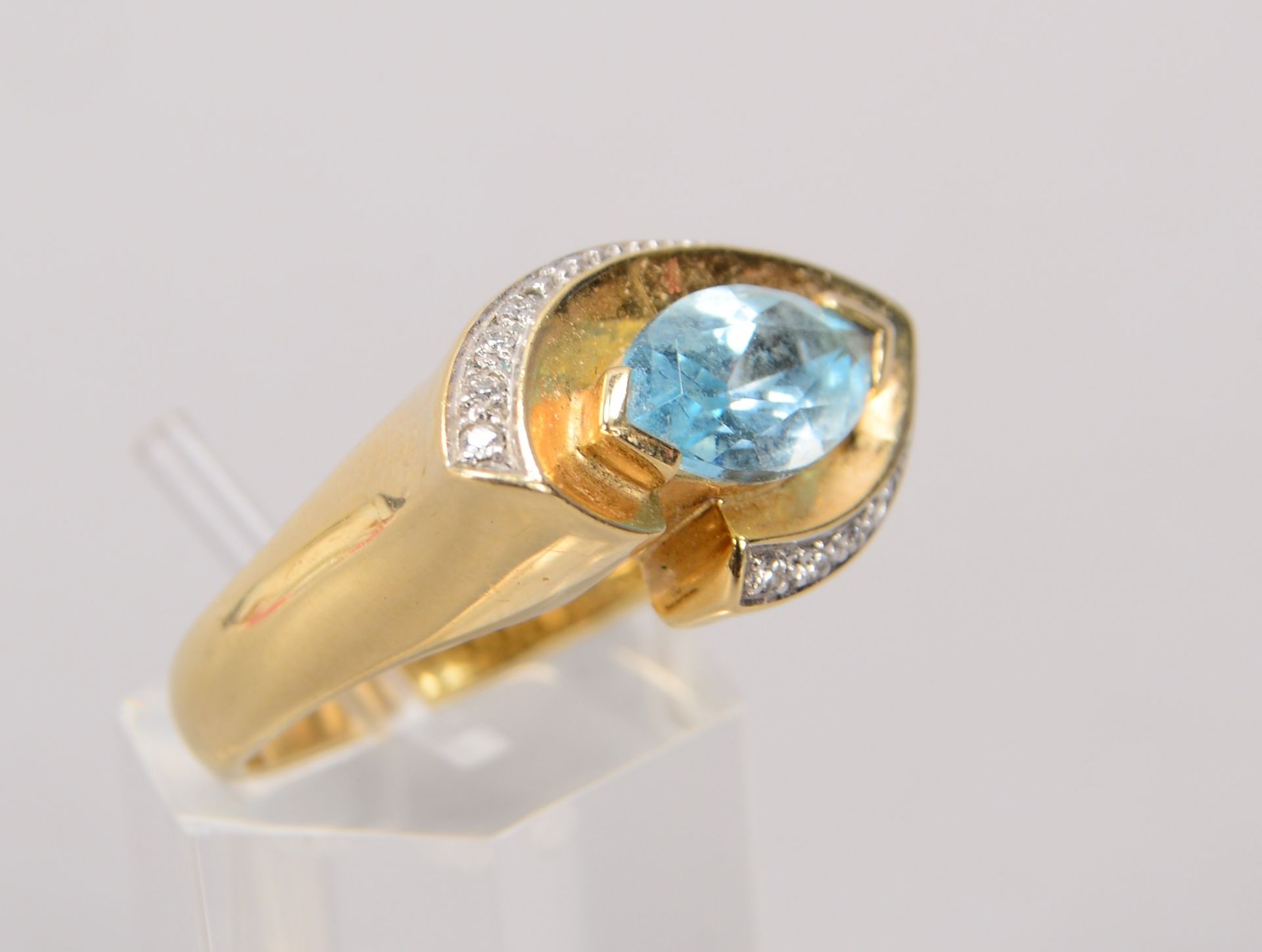 Ring, 585 GG, besetzt mit einzelnem Blautopas, Stein im Navetteschliff, und mit Bgeleitdiamanten/zus