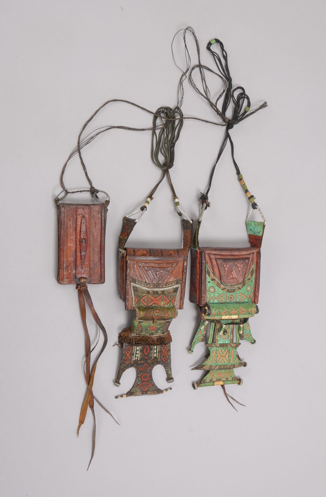 3 Amulette/Taschen (Tuareg/Mali -?), ornamental gepr&auml;gtes Leder, verschiedene Ausf&uuml;hrungen