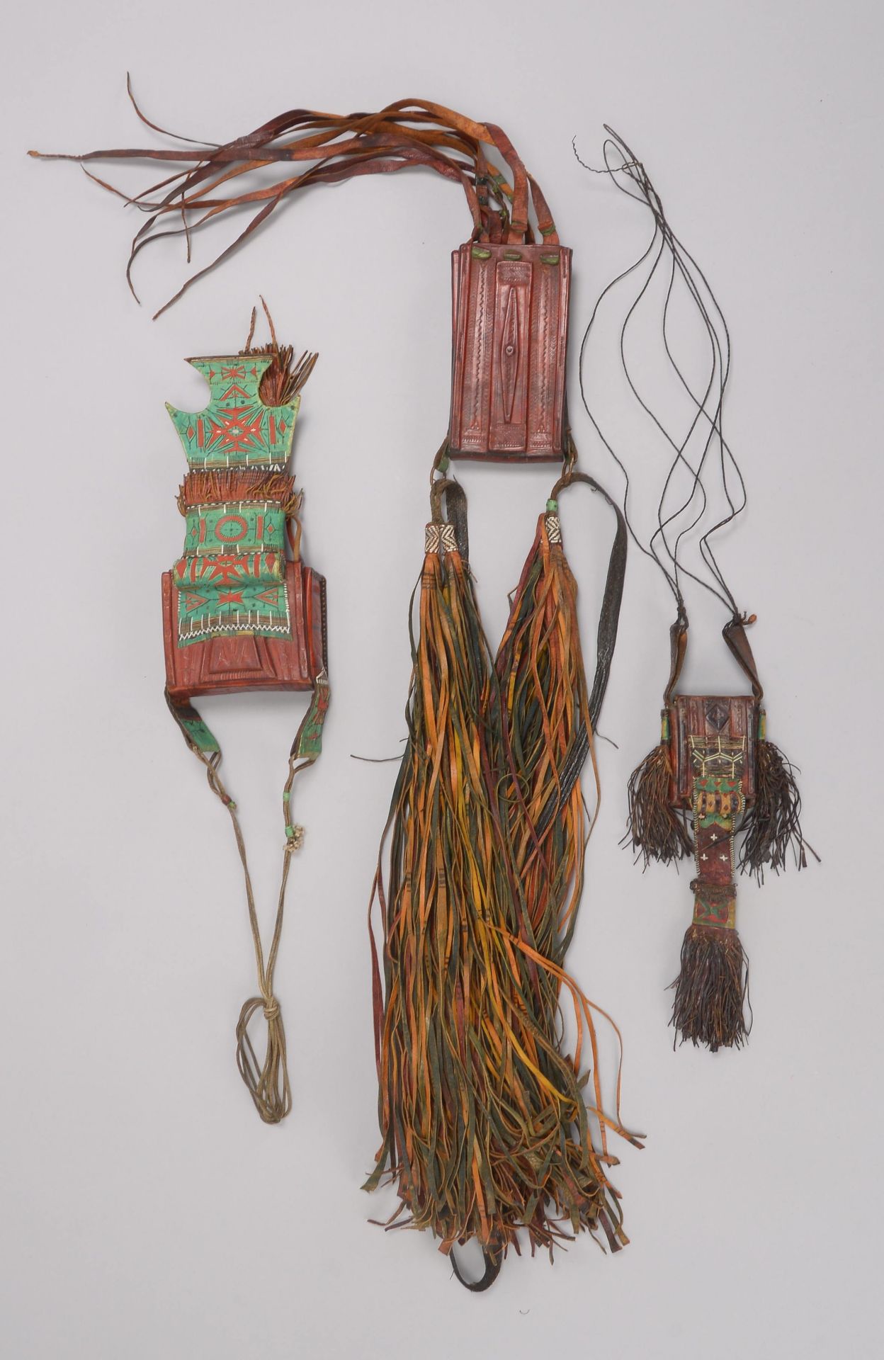 3 Amulette/Taschen (Tuareg/Mali -?), ornamental gepr&auml;gtes Leder, verschiedene Ausf&uuml;hrungen