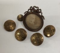 A set of four gilt buttons together with a small g