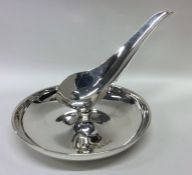 A heavy circular silver inkstand of stylised form.