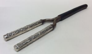 A pair of silver handled curling tongs. Approx. 14