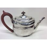 A George III oval silver teapot with crested side.