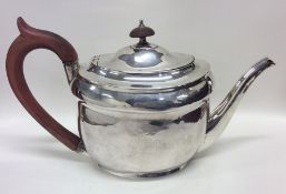 A George III oval silver teapot with crested side.