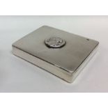 A silver plated hinged top box with central plaque