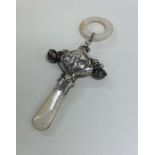 A silver and MOP rattle decorated with a child sce