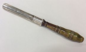 A Georgian silver apple corer with turned handle.