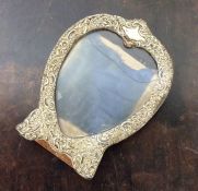 A heart shaped silver picture frame embossed with