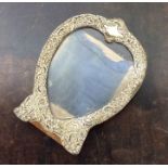 A heart shaped silver picture frame embossed with