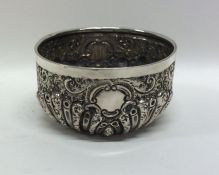 A small silver embossed bowl with fluted decoratio