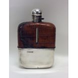 A large silver and glass hip flask with crocodile