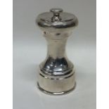 A modern silver pepper mill of typical design. App