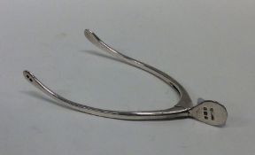 A pair of silver sugar tongs in the form of a wish