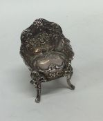 A silver table toy in the form of a chair bearing