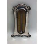 A cased silver thermometer with shaped decoration.