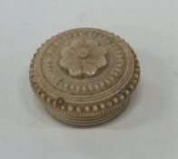 A small carved ivory pill box in the form of a flo