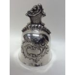 A Continental silver embossed bell with scroll dec