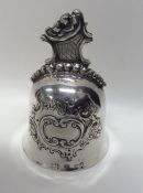 A Continental silver embossed bell with scroll dec