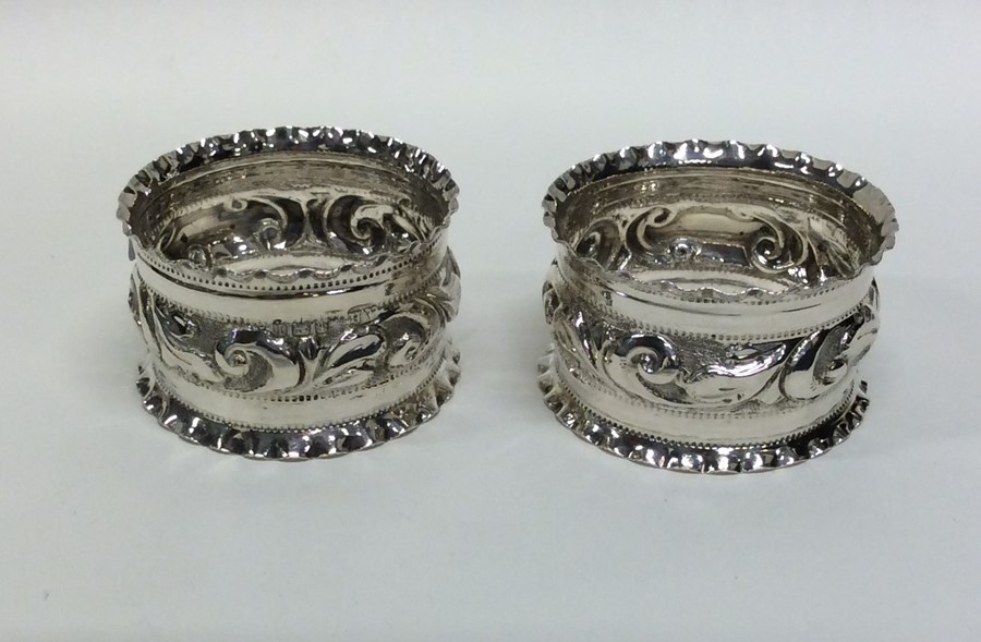 A pair of Edwardian silver embossed napkin rings.