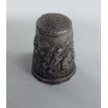 A large silver thimble decorated with a hunting sc