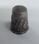 A large silver thimble decorated with a hunting sc