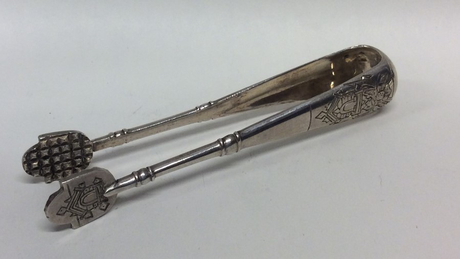 A pair of heavy Russian cast ice tongs engraved wi