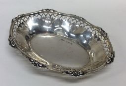 A small silver pierced pin dish with shell border.
