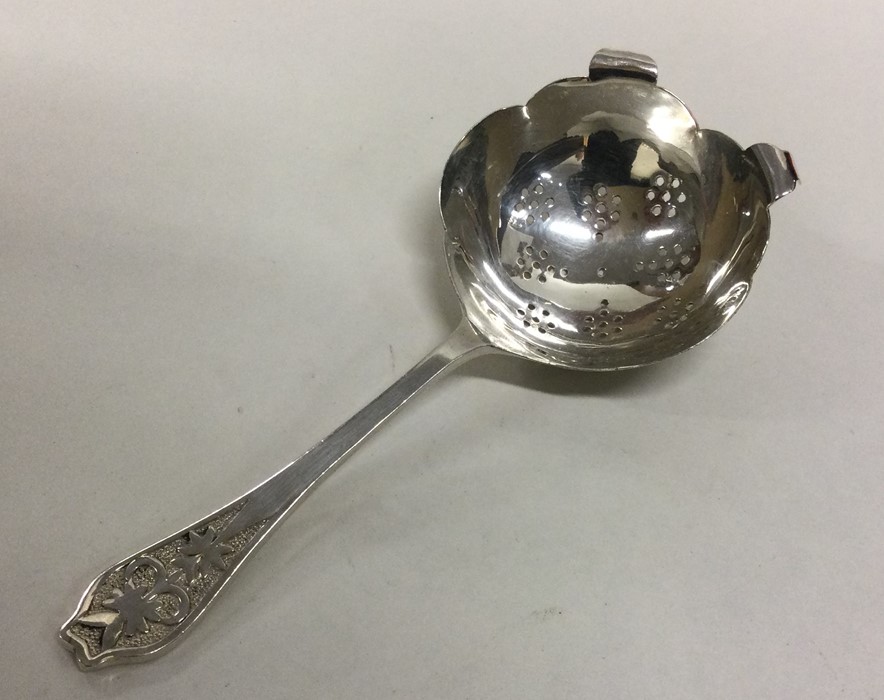 A heavy Edwardian silver tea strainer with pierced
