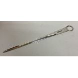 A tapering silver meat skewer with ring thumb piec