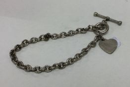 A modern silver bracelet with heart shaped fob. Ap