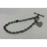 A modern silver bracelet with heart shaped fob. Ap