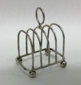 An Edwardian silver five bar toast rack on ball fe