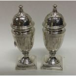 A pair of Victorian fluted silver peppers on squar